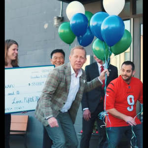 Group with a large check, balloons, getting ready to go inside the RODI restaurant