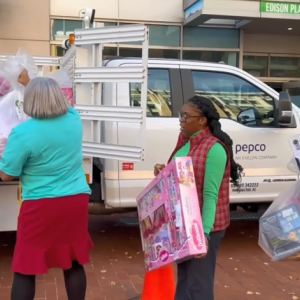 Volunteers lined up to help Santa load presents on the back of a Pepco truck.
