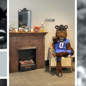 Buster Bronco shown seated in a chair next to a fireplace.