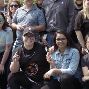 A group photo of people holding plastic forks