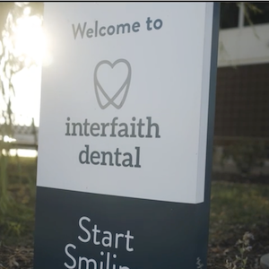 Sign showing: Welcome to interfaith dental; start smiling. 
