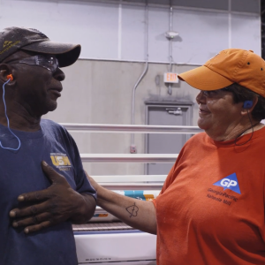 Amy and another employee, smiling in a warehouse.