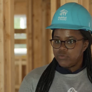 Ryan Estmond wearing a safety hat inside of a building under construction  