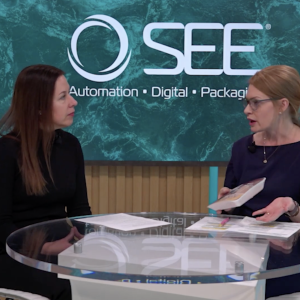 2 people talking in front of SEE logo