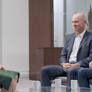 Three seated people talking.