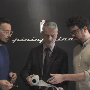 Alfredo Palma with two others looking at a roll of fabric.