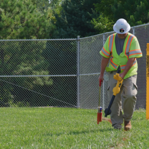 Person wearing safety vest marks ground