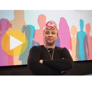 Image of a Black woman wearing a black top with her hair wrapped in a colorful scarf 