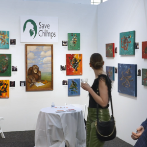 An art display "Save the Chimps" in a gallery. Patrons looking at the art.