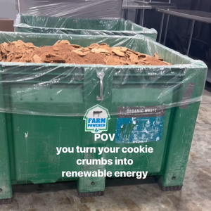 A large green bin filled with waste cookies and crumbs. "POV you turn your cookie crumbs into renewable energy"