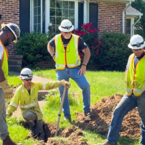 Larry Rohm and teammates digging in a residential yard.
