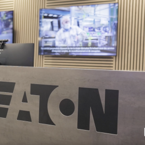 Large reception desk with the name "EATON" printed on it. Behind are several screens