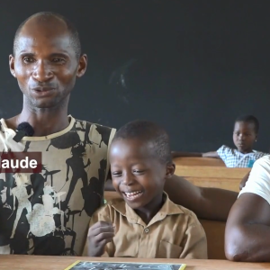 Two adults sitting with a child in a classroom.