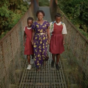 Woman walking across a bridge with her two young daughters
