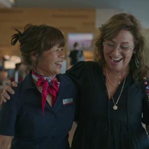 Two people walking arm in arm and laughing