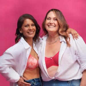 2 people smiling and showing their bras