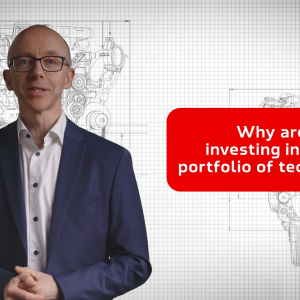 "Why are we investing in a broad portfolio of technology?" On the left a person speaking. A blueprint of engines in the background.