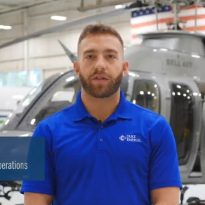 A Duke Energy employee interviewed in front of a helicopter in a hanger. 