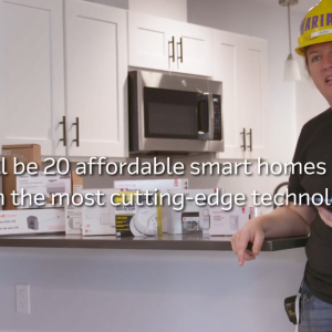 A worker standing next to a kithen island with many different tech products on it.