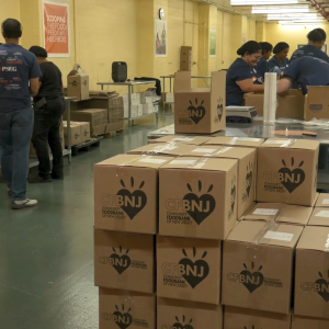volunteers packing boxes with food items.