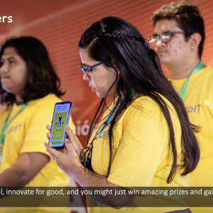 3 students showing off their app on stage