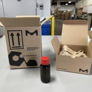 Two boxes with the MilliporeSigma logo and a small brown vial on a table in a warehouse
