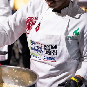 A chef cooking food in a big pot