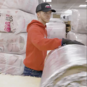 worker rolling up Mineral Wool