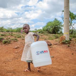 A girl carries water home in Kenya. 