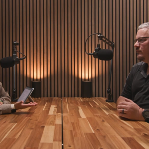 Two people speaking into microphones