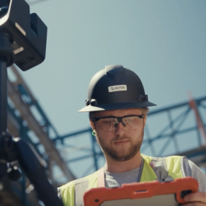 Worker in hardhat consulting tablet at a construction site
