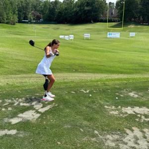 Lulu swinging a club on the green