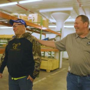 Two employees walking together in a warehouse