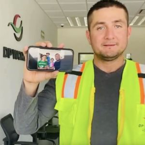 Man holding a phone with picture of his family on it