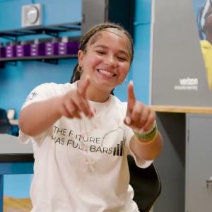 A person smiling and pointing to the camera