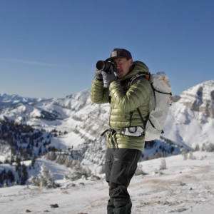 Jimmy Chin taking a photo on a mountaintop 