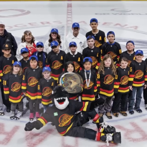 Kids posing on the ice with mascot