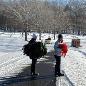 Two people holding wreaths and ribbons 
