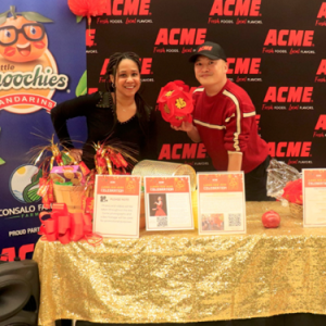 People posing at booth with "ACME" logo