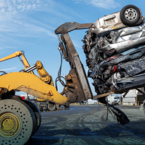 A photo of a forklift holding up 4 crushed cars