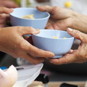 Hands sharing bowls of food