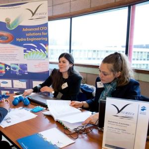 Virginie Barbieux and coworker in dark blue blazers sitting at a table