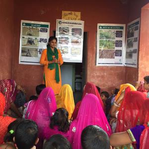 one person stands in front of a small crowd with posters behind them