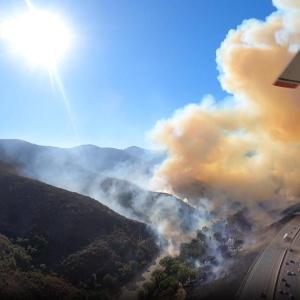 An S-76 helicopter and three helitankers patrol the Southern California skies