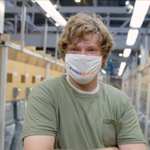 Photo of man in green t-shirt with a mask covering his nose and mouth