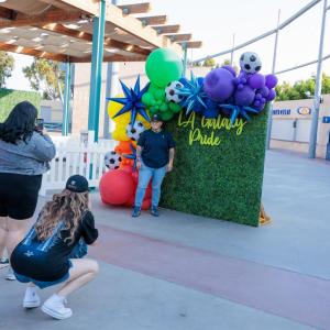 LA Galaxy fans taking photos at an LA Galaxy Pride Night photo station.
