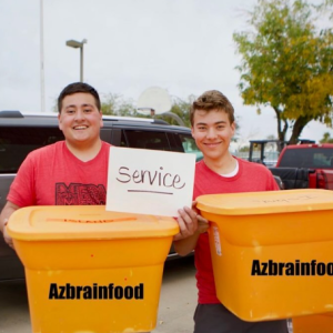 Two men holding up orange containers with black text