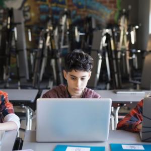 3 kids using laptops