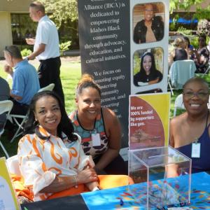 Three people sitting at booth