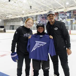 Coach Dominique Petrie and LA Kings Alumnus Jordan Nolan pose with signed jersey for participant 